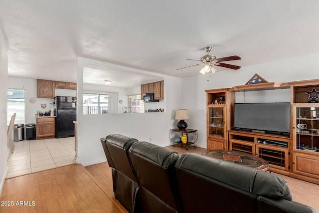 living room featuring plenty of natural light, light wood-type flooring, and ceiling fan