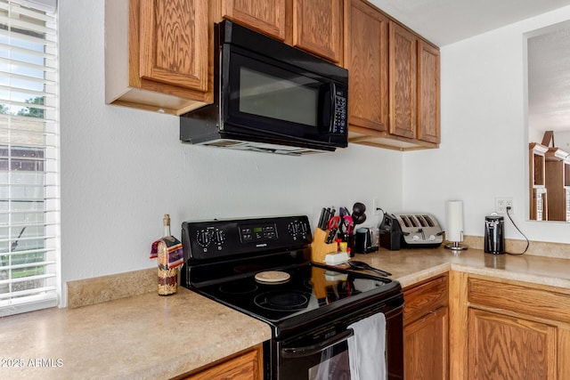kitchen featuring light countertops, plenty of natural light, and black appliances