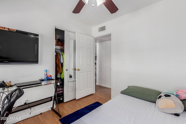 bedroom with a ceiling fan, a closet, wood finished floors, and visible vents