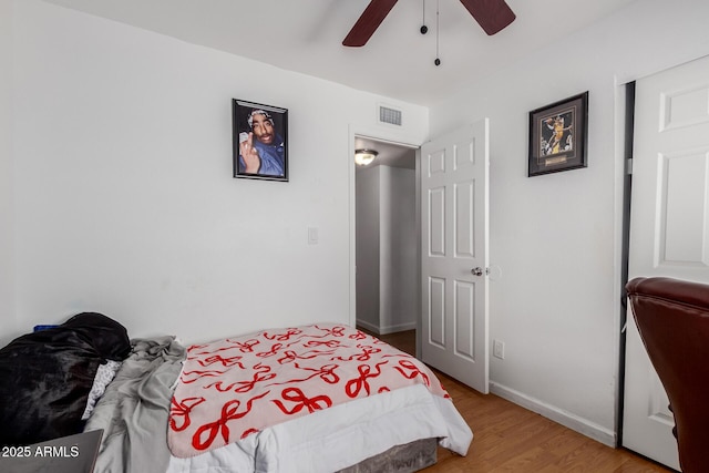 bedroom featuring a ceiling fan, baseboards, visible vents, and light wood finished floors