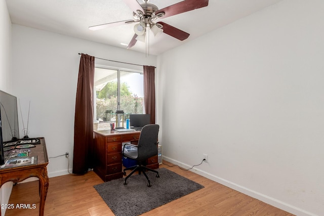 office area with baseboards, light wood finished floors, and ceiling fan