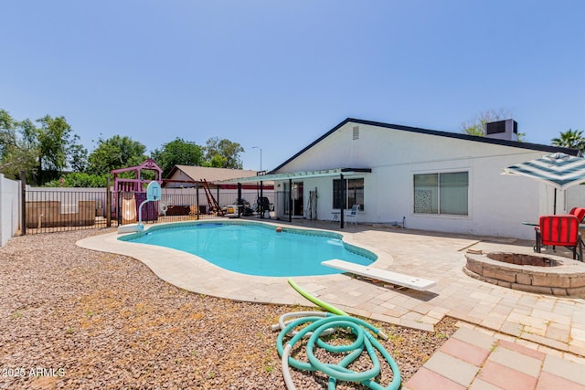 view of swimming pool with a diving board, an outdoor fire pit, a fenced backyard, a fenced in pool, and a patio area