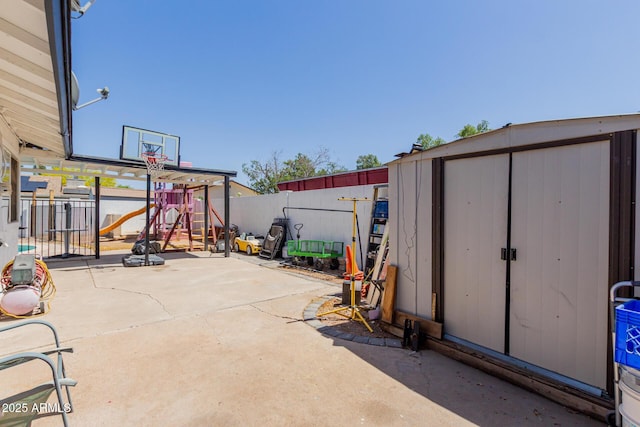 view of patio with a fenced backyard, an outbuilding, a playground, and a shed