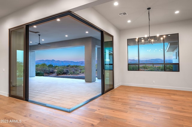 entryway with light hardwood / wood-style flooring, a mountain view, and ceiling fan with notable chandelier