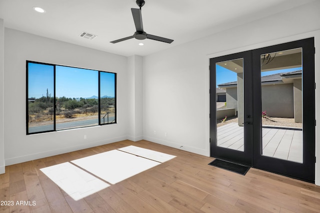 empty room featuring french doors, light hardwood / wood-style floors, and ceiling fan