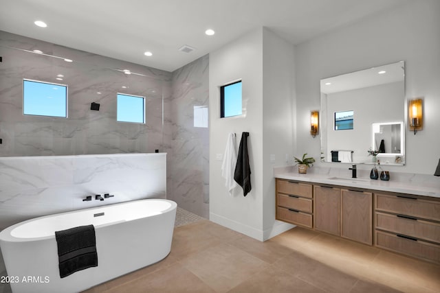 bathroom with vanity, tile floors, and a tub