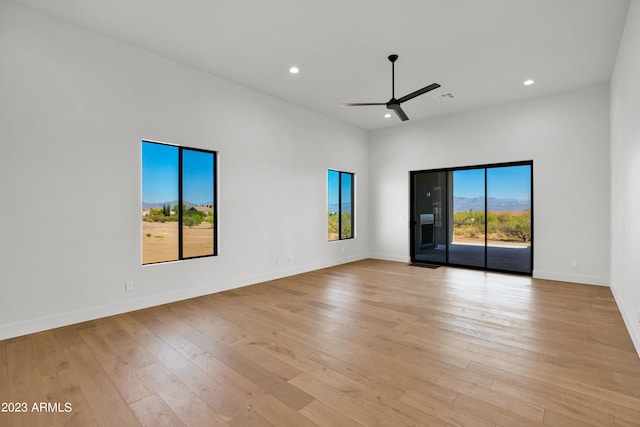 empty room with ceiling fan and light hardwood / wood-style floors