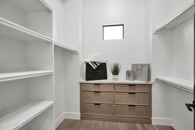 walk in closet with dark wood-type flooring