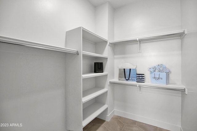 walk in closet with light tile floors