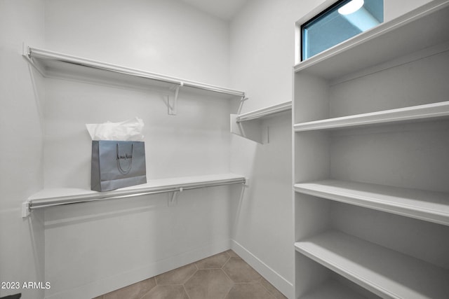 spacious closet with light tile floors