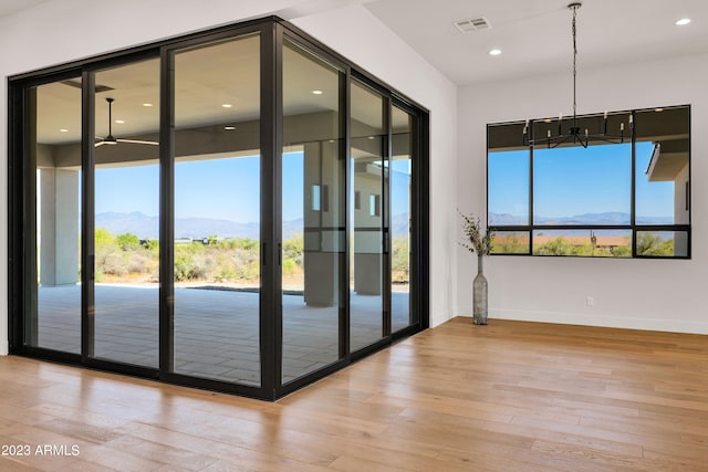 doorway with a mountain view, french doors, light hardwood / wood-style floors, and a notable chandelier