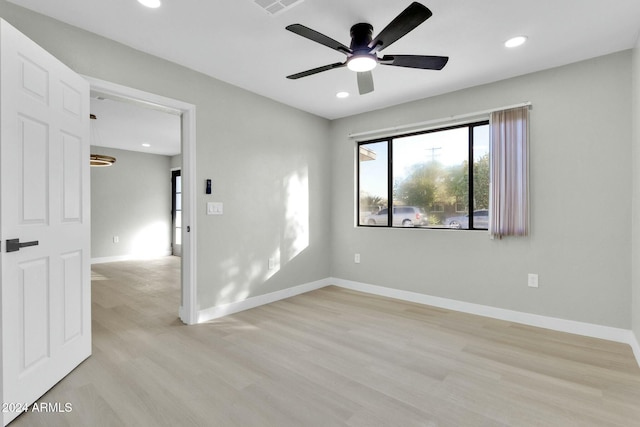 empty room with ceiling fan and light hardwood / wood-style flooring