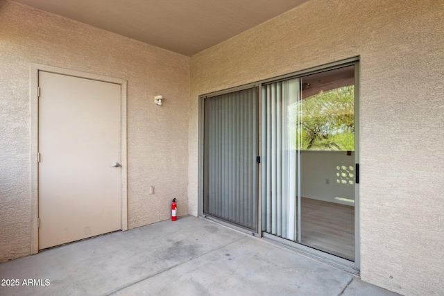 doorway to property featuring stucco siding