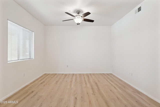 empty room featuring baseboards, a ceiling fan, wood finished floors, and visible vents