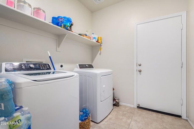 washroom featuring separate washer and dryer and light tile patterned floors