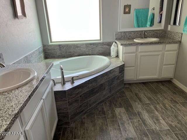1067 N Jacobs Rd, Saint David, AZ 85630 - full bath featuring two vanities, a garden tub, and wood finished floors