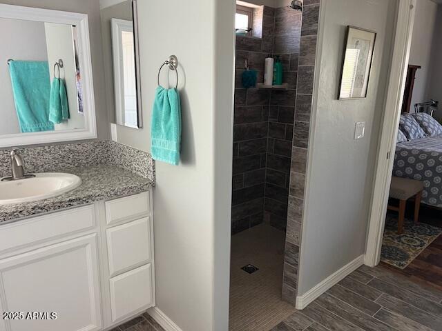 1067 N Jacobs Rd, Saint David, AZ 85630 - full bathroom featuring a walk in shower, vanity, connected bathroom, wood finished floors, and baseboards