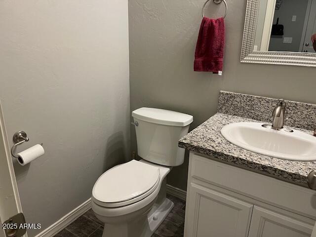 1067 N Jacobs Rd, Saint David, AZ 85630 - bathroom featuring toilet, vanity, and baseboards