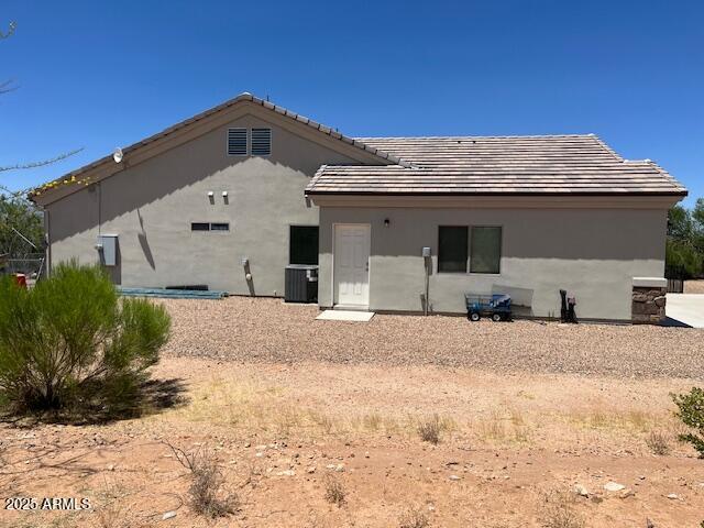 1067 N Jacobs Rd, Saint David, AZ 85630 - rear view of house featuring central air condition unit, a tiled roof, and stucco siding
