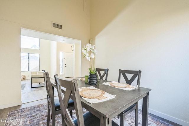 dining room with baseboards and a high ceiling