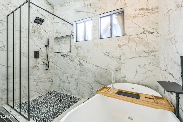 full bathroom with a marble finish shower and a freestanding bath