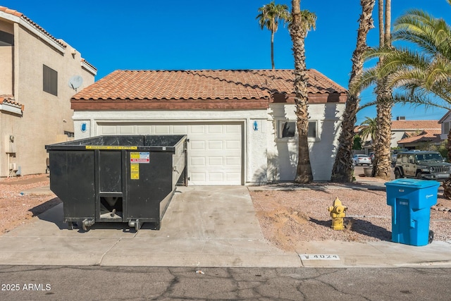 mediterranean / spanish home with a tiled roof, concrete driveway, stucco siding, and a garage