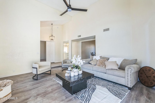 living room featuring high vaulted ceiling, wood finished floors, ceiling fan, and baseboards