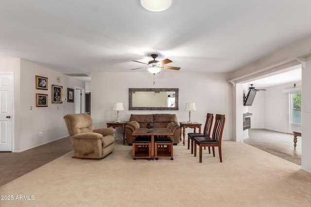 carpeted living room with a ceiling fan and a fireplace
