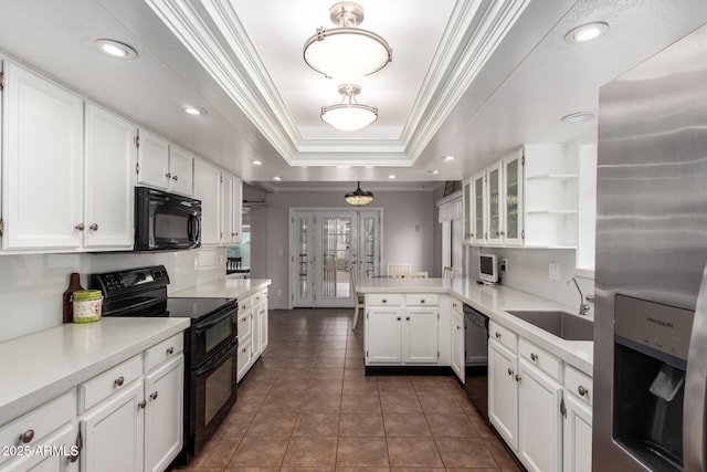 kitchen featuring a peninsula, a raised ceiling, a sink, open shelves, and black appliances