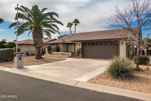 view of front of home with stucco siding, a garage, and concrete driveway