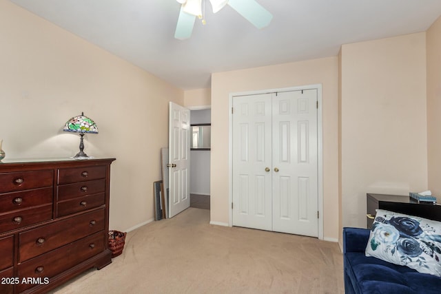 living area featuring baseboards, ceiling fan, and light colored carpet