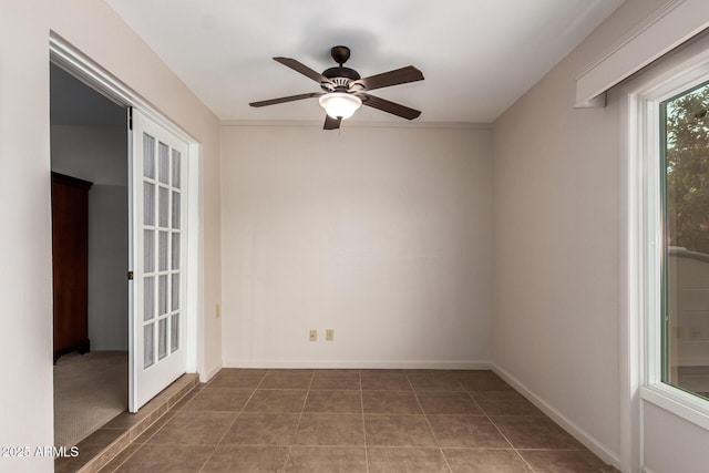 spare room featuring baseboards, ceiling fan, and tile patterned floors