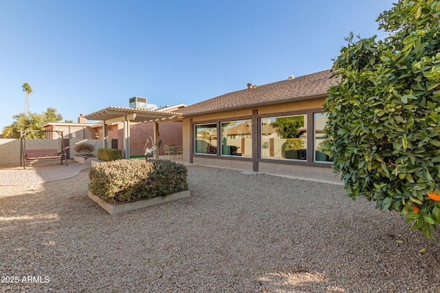 back of property with stucco siding, fence, a patio, a pergola, and a chimney