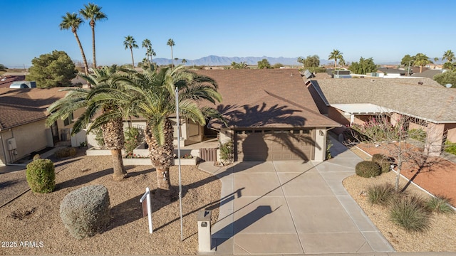 view of front facade featuring driveway, an attached garage, and a mountain view