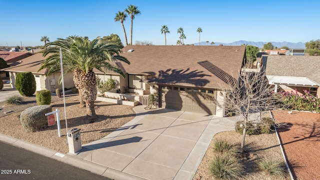 view of front of property featuring driveway, an attached garage, and a mountain view
