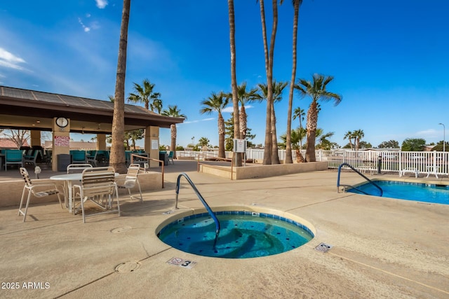community pool featuring a community hot tub, fence, and a patio area