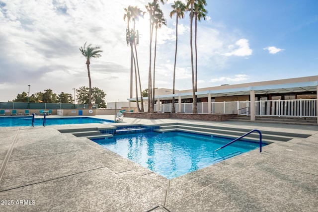 pool featuring fence and a patio area