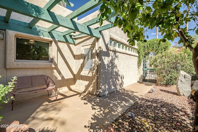 view of side of property featuring a pergola and a patio area