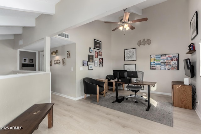 office area featuring ceiling fan, light hardwood / wood-style flooring, and beamed ceiling