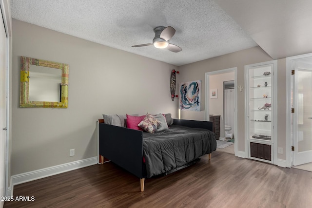 bedroom with ensuite bathroom, a textured ceiling, ceiling fan, and dark wood-type flooring