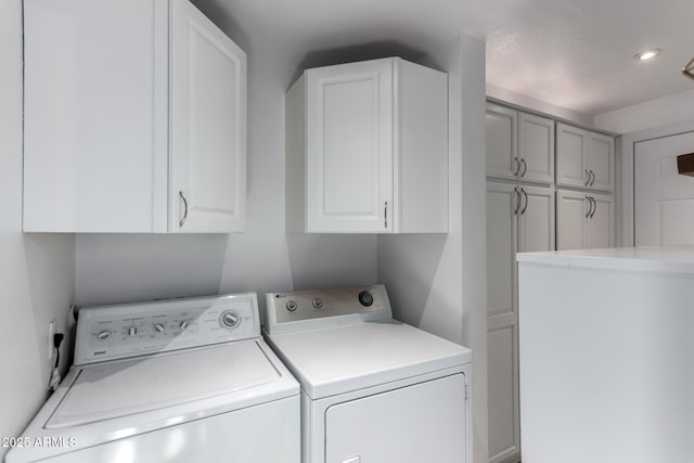 washroom with independent washer and dryer and cabinets