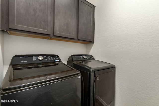 laundry area with cabinet space, independent washer and dryer, and a textured wall