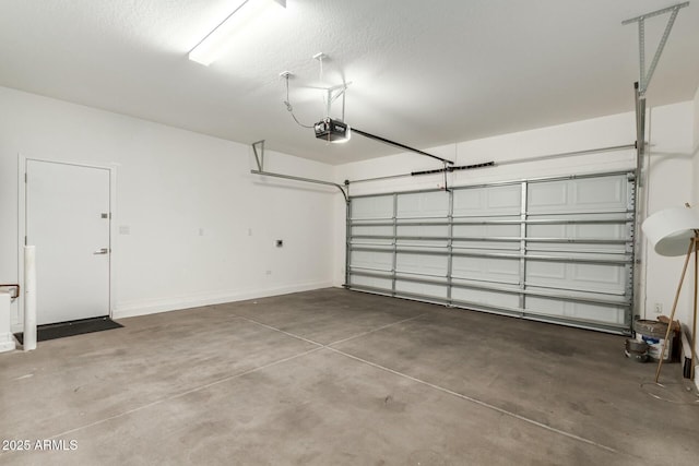 garage with a garage door opener and baseboards