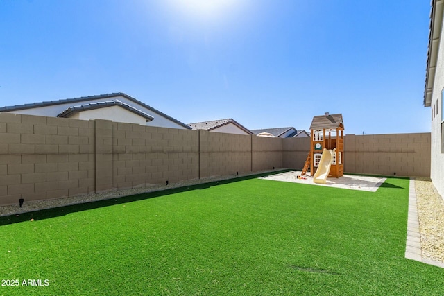 view of yard featuring a fenced backyard and a playground