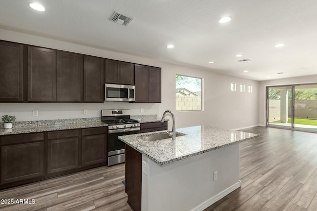 kitchen featuring light wood-type flooring, visible vents, appliances with stainless steel finishes, and a sink