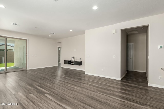 empty room featuring recessed lighting, dark wood-style floors, visible vents, and baseboards