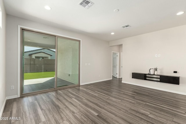 empty room featuring recessed lighting, visible vents, and wood finished floors