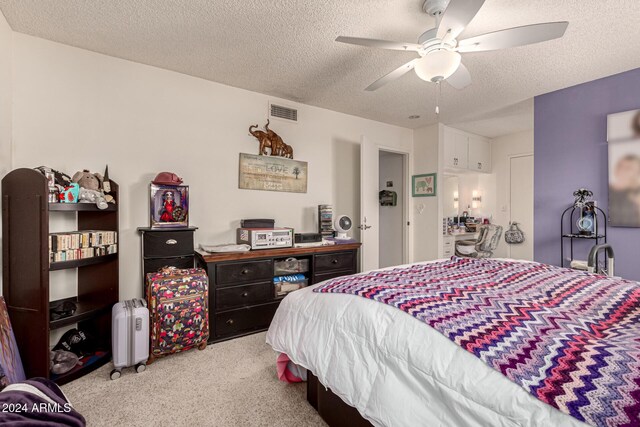 carpeted bedroom featuring ceiling fan and a textured ceiling