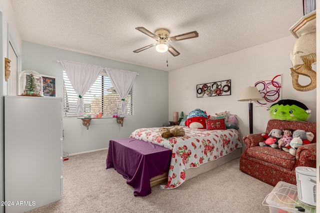 bedroom featuring a textured ceiling, light colored carpet, and ceiling fan