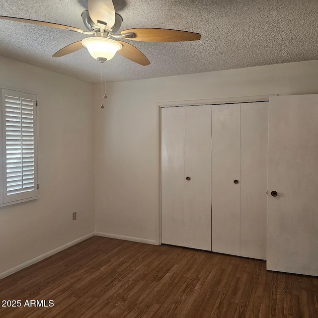 unfurnished bedroom featuring a textured ceiling, ceiling fan, a closet, and dark hardwood / wood-style floors